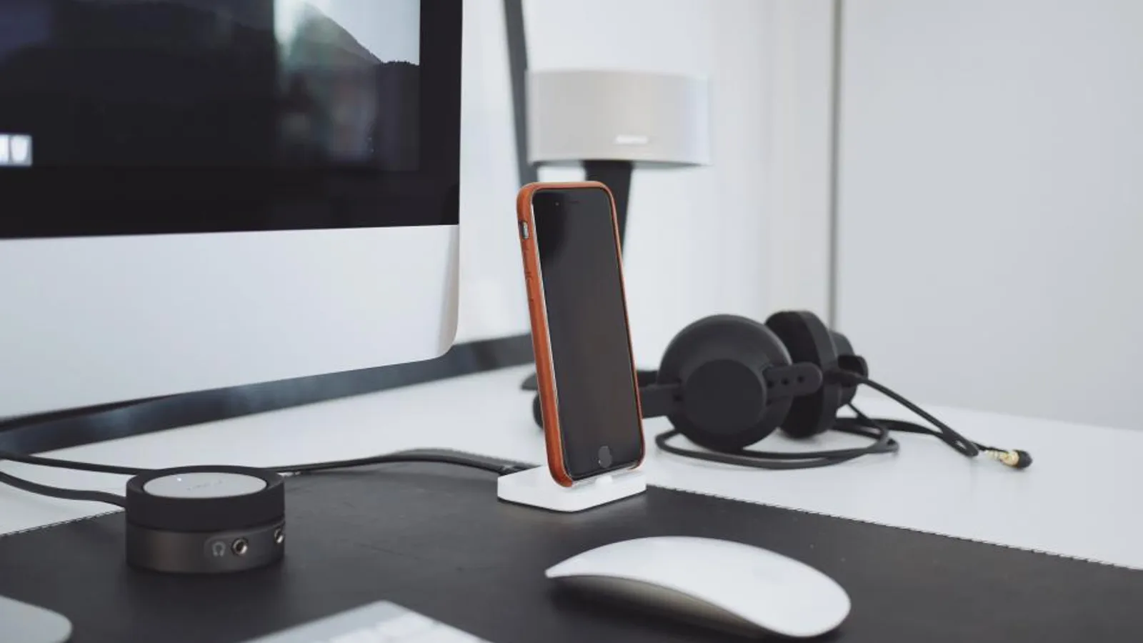 A sales development rep wearing a headset makes calls at a desk with a laptop in an open office.