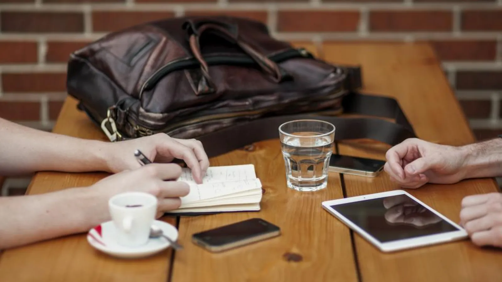 A job candidate and a hiring manager talking across a table in a bright office during an interview.