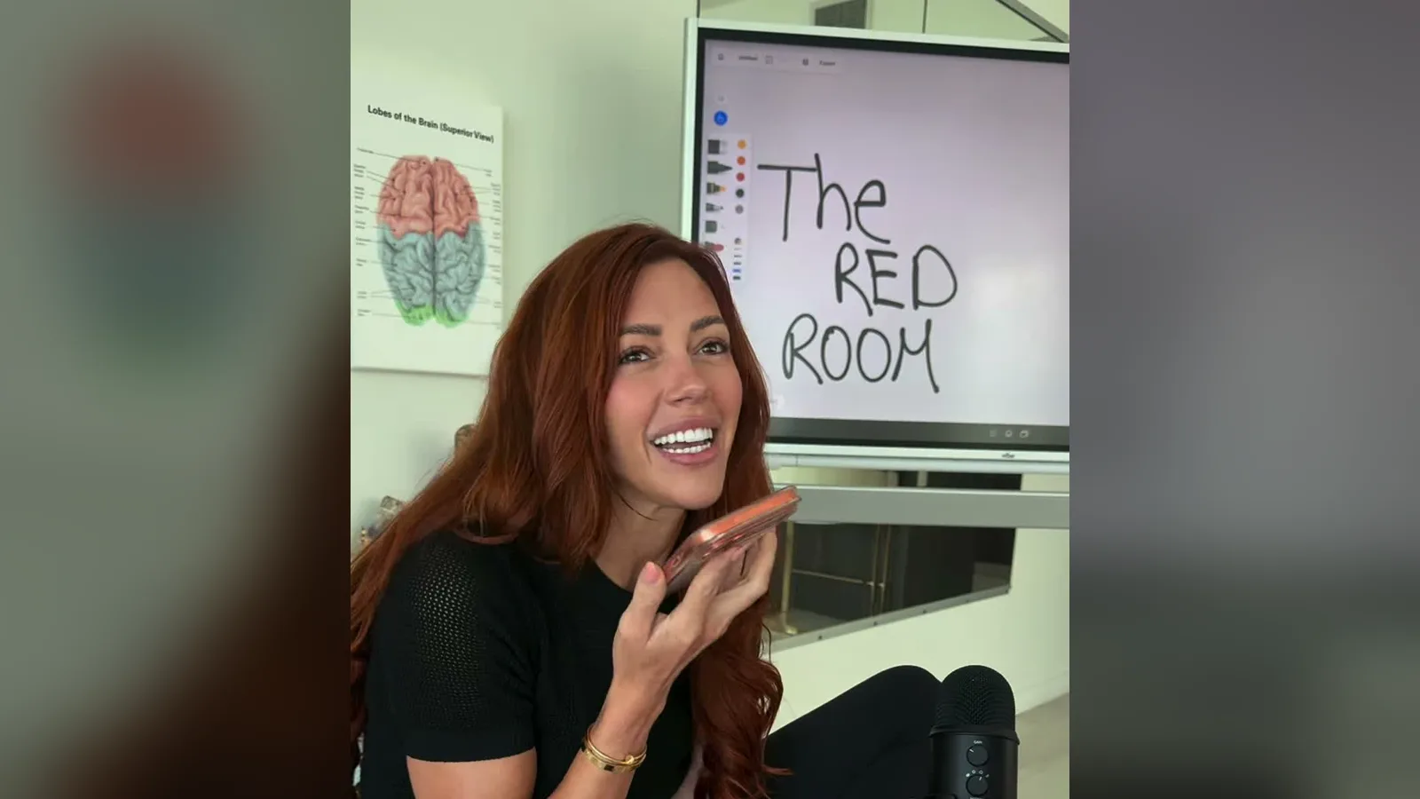 Kayla Hodges on a phone call during an AI sales role play, in front of a screen that says The RED Room.